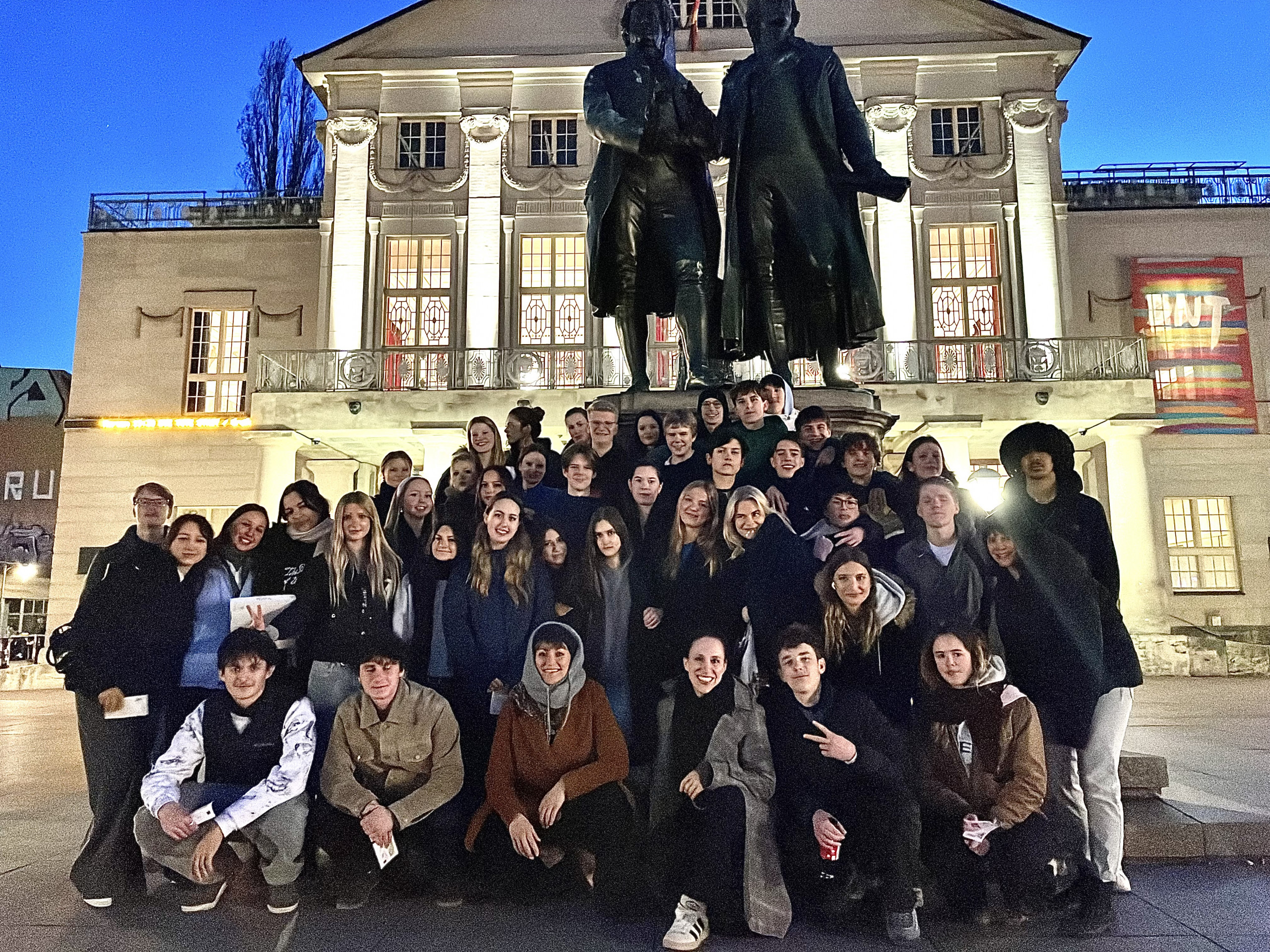 Eine Gruppe Schüler und Schülerinnen in Weimar, vor einer Statue