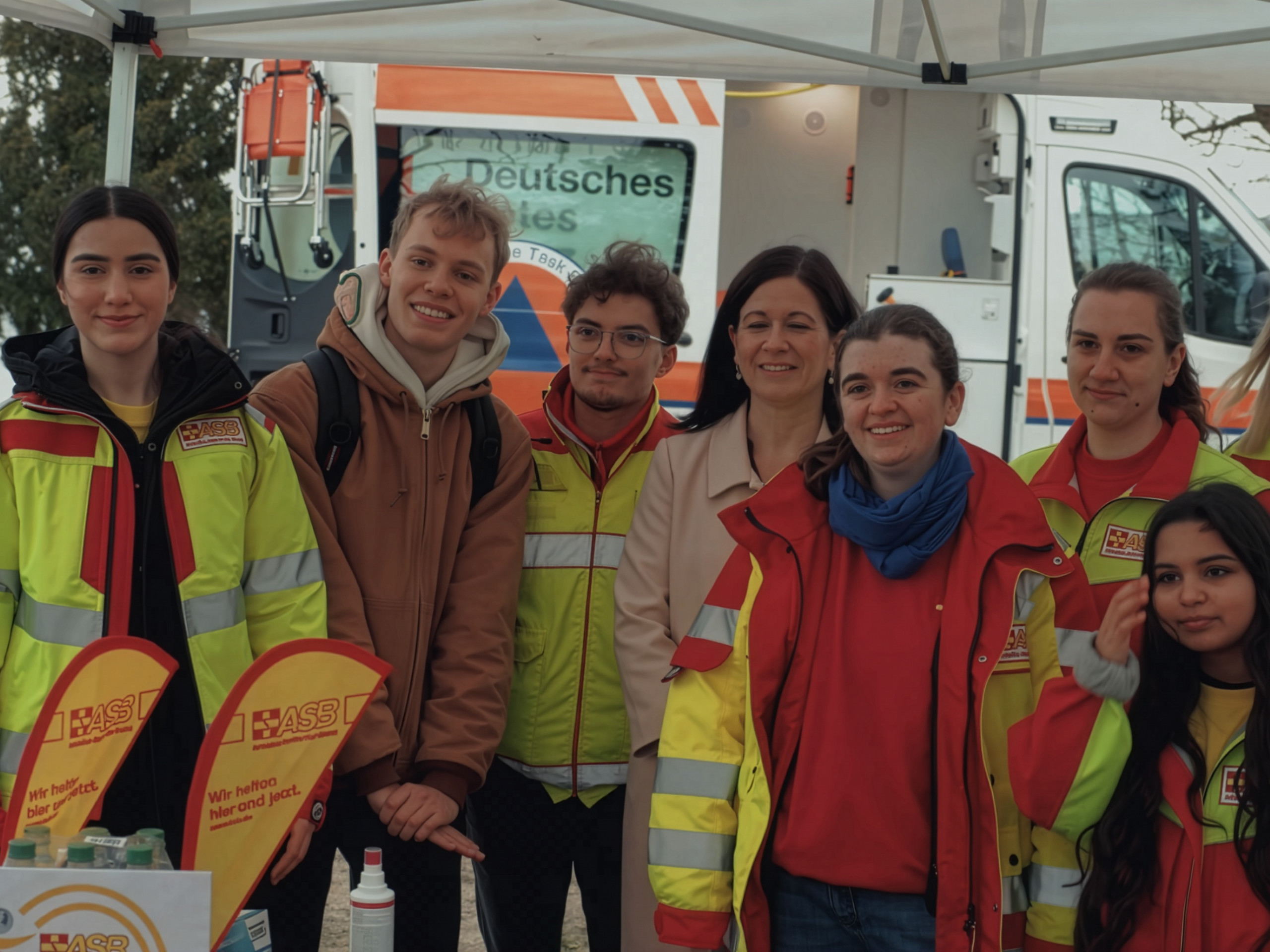 Eine Gruppe Schülerinnen und Schüler posieren zusammen mit Mitarbeitenden des Deutschen Roten Kreuzes