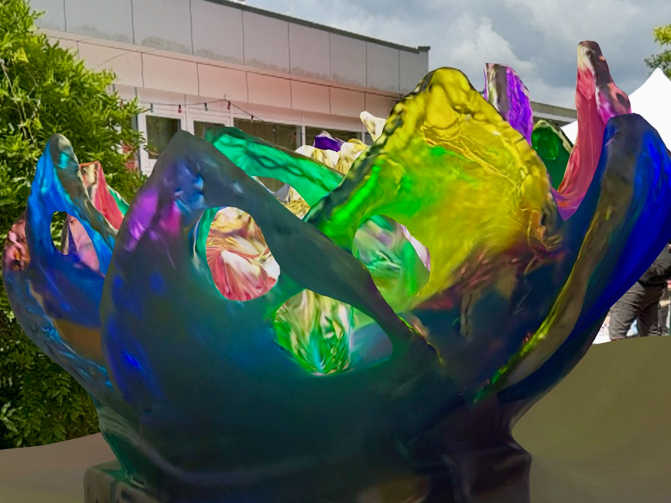 Bunte, transparente Skulptur in Form einer geöffneten Blüte mit unregelmäßigen, welligen Blättern und Aussparungen loading=